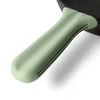 Close up of Greater Goods green silicone handle cover on a Greater Goods cast iron handle. 
