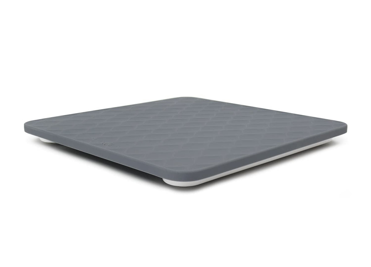 Gray bathroom scale with textured, silicone surface on a white background