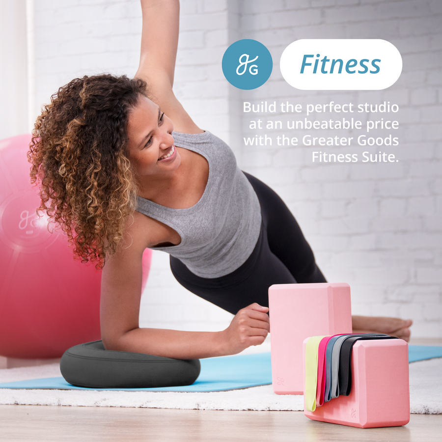 A woman doing yoga on a yoga mat, with balance disc, yoga blocks, resistance bands, and a yoga ball surrounding her. Text reads, "Fitness: Build the perfect studio at an unbeatable price with the Greater Goods Fitness Suite."