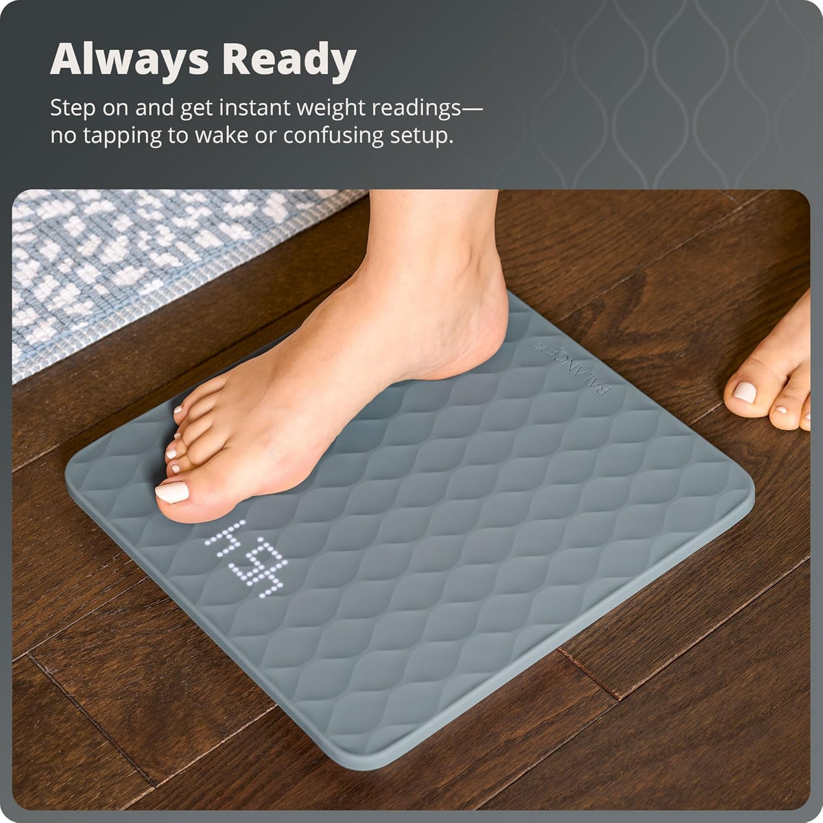 A foot stepping onto a gray silicone scale with text that reads, "Always Ready: Step on and get instant weight readings. No tapping to wake or confusing setup."

