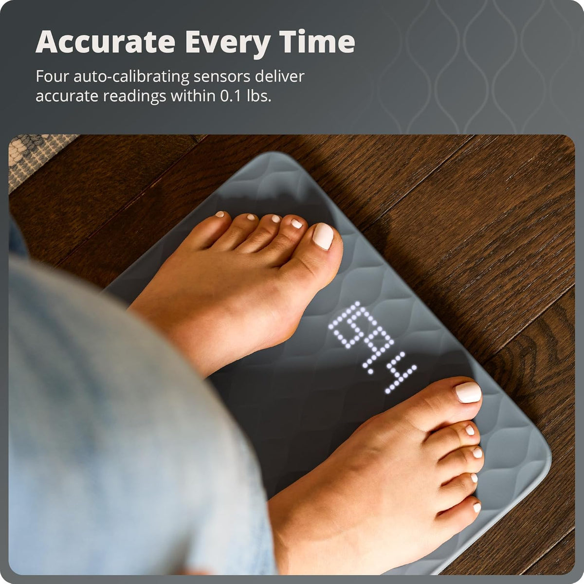 Feet standing on a gray silicone bathroom scale with text that reads, "Accurate Every  Time: Four auto-calibrating sensors deliver accurate readings within 0.1 lbs."