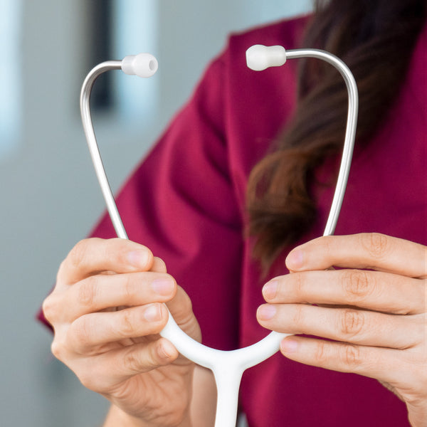 A nurse holding a white stethoscope. 